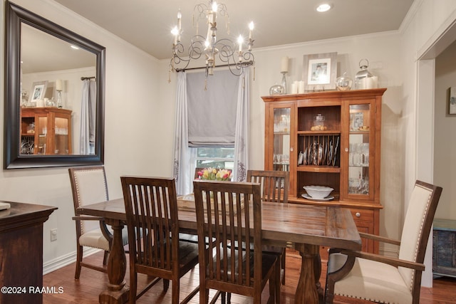 dining room with wood-type flooring, an inviting chandelier, and ornamental molding