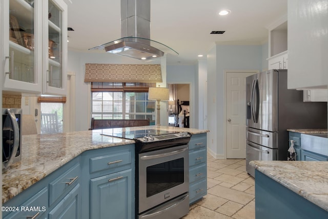 kitchen featuring white cabinetry, appliances with stainless steel finishes, light stone countertops, island range hood, and blue cabinets