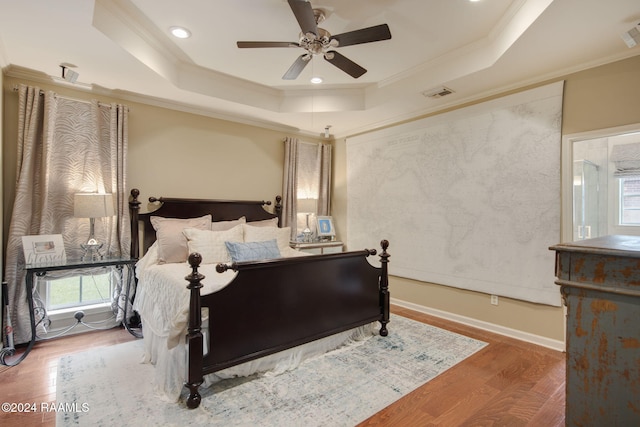 bedroom with ceiling fan, crown molding, and a raised ceiling