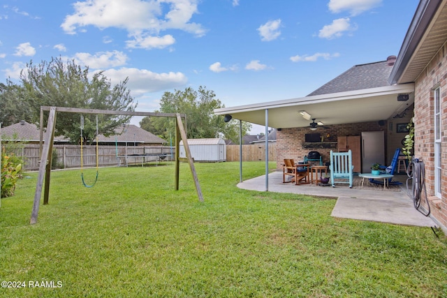 view of yard featuring ceiling fan, a patio, and a storage unit