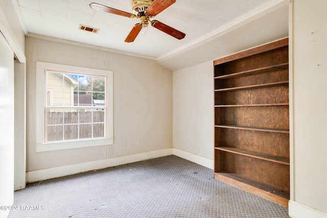 carpeted spare room with lofted ceiling, ceiling fan, and crown molding