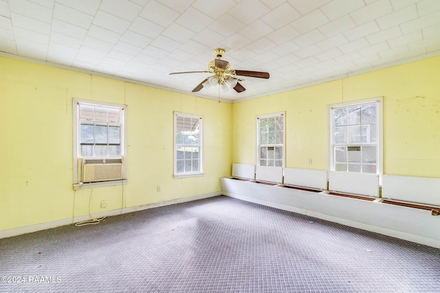 empty room featuring ceiling fan, cooling unit, carpet flooring, and ornamental molding