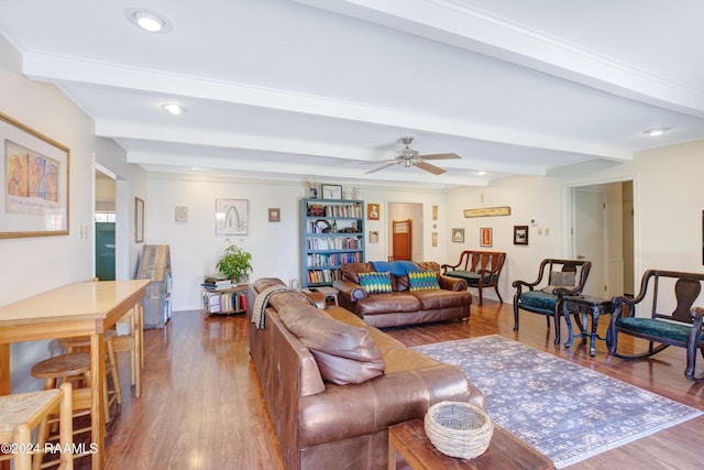 living room with ceiling fan, beamed ceiling, and wood-type flooring