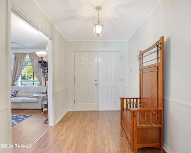 foyer entrance featuring light wood-type flooring and ornamental molding