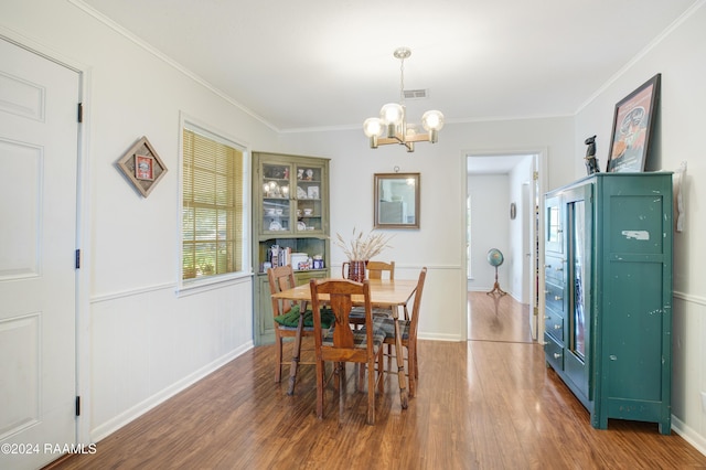 dining area featuring a notable chandelier, crown molding, and dark wood-type flooring