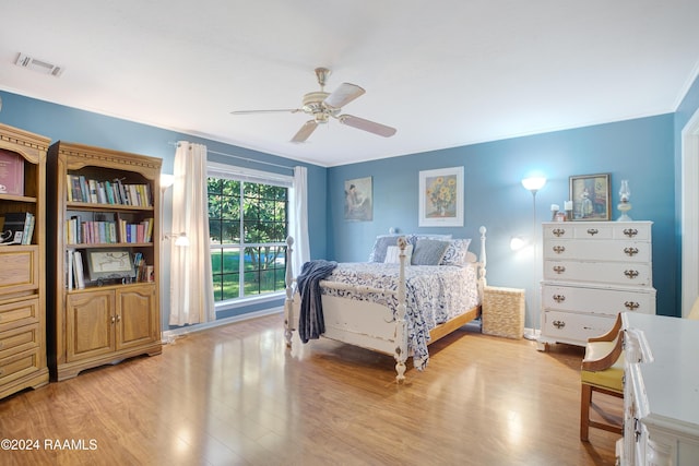 bedroom featuring ceiling fan, light hardwood / wood-style floors, and crown molding