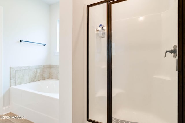 bathroom featuring tile patterned flooring and separate shower and tub