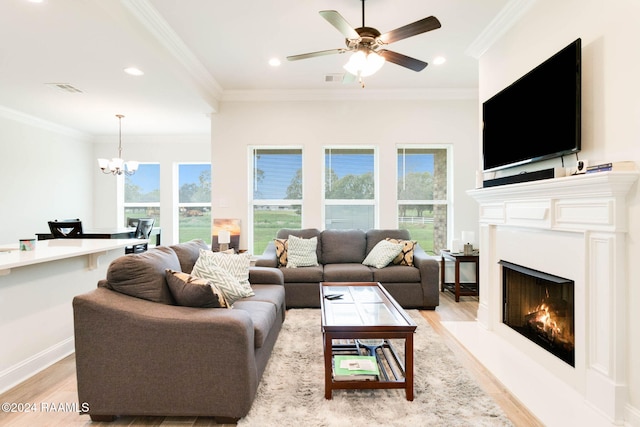 living room with a healthy amount of sunlight, light wood-type flooring, and crown molding