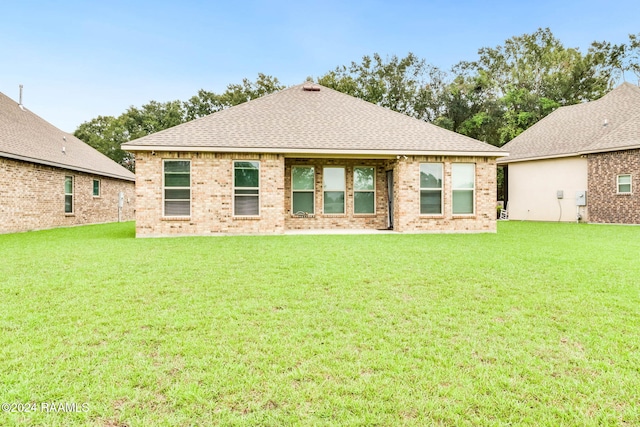 rear view of house featuring a lawn