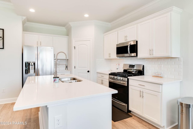 kitchen featuring white cabinets, appliances with stainless steel finishes, sink, and an island with sink