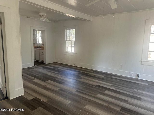 spare room featuring dark hardwood / wood-style flooring, ceiling fan, crown molding, sink, and beamed ceiling