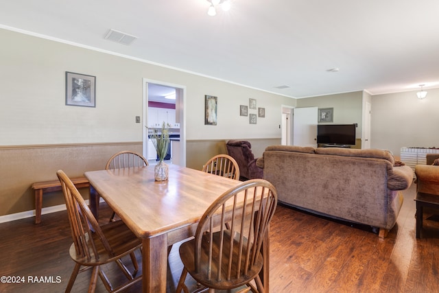 dining area with crown molding and dark hardwood / wood-style floors