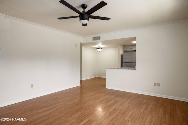 unfurnished room with ceiling fan, wood-type flooring, and ornamental molding