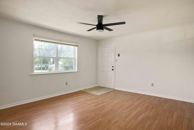 empty room featuring ceiling fan, crown molding, a textured ceiling, and hardwood / wood-style flooring