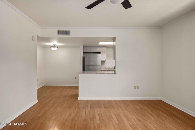 unfurnished living room with light hardwood / wood-style floors, ceiling fan, and ornamental molding