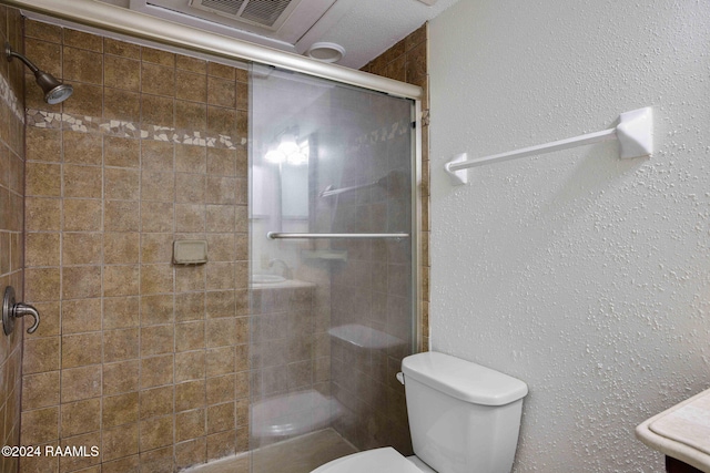 bathroom with an enclosed shower and toilet