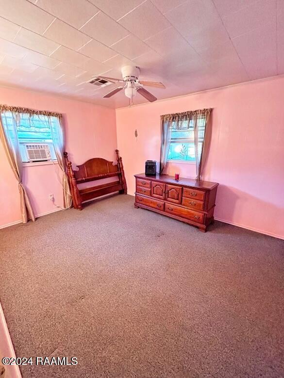 living area with carpet flooring, ceiling fan, plenty of natural light, and cooling unit