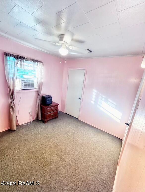 carpeted empty room with ceiling fan and cooling unit