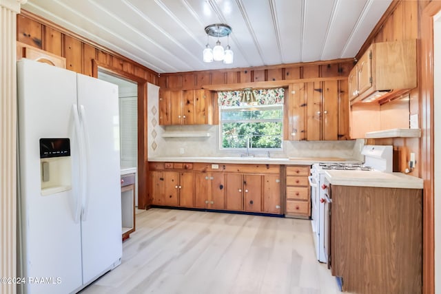 kitchen featuring backsplash, white appliances, sink, light hardwood / wood-style flooring, and a notable chandelier