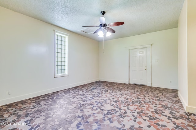 spare room featuring ceiling fan and a textured ceiling