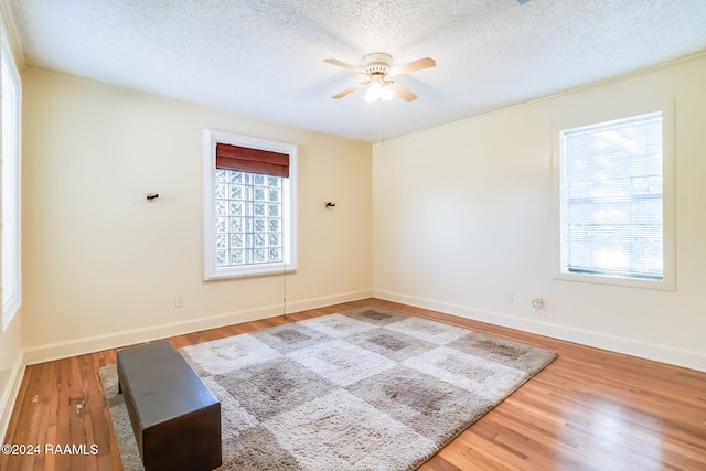 spare room with ceiling fan, a textured ceiling, and hardwood / wood-style flooring