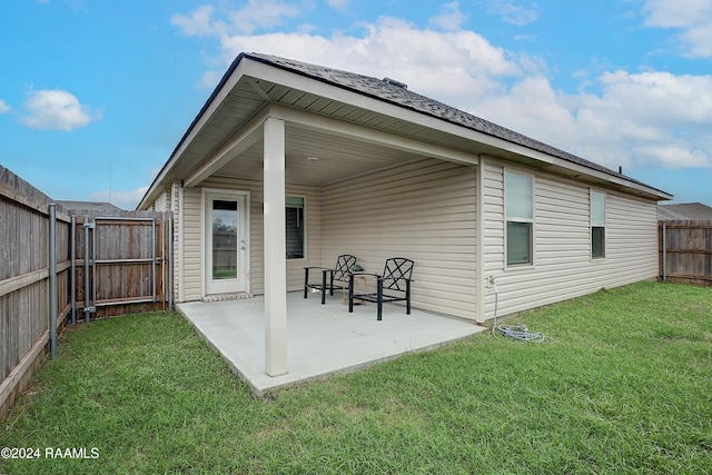 rear view of house with a lawn and a patio area