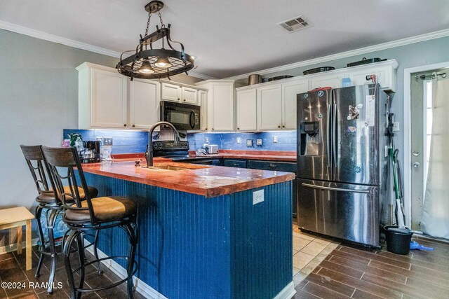 1049 Gary Dr, Breaux Bridge, LA 70517 - kitchen featuring black appliances, wood counters, a peninsula, crown molding, and white cabinets