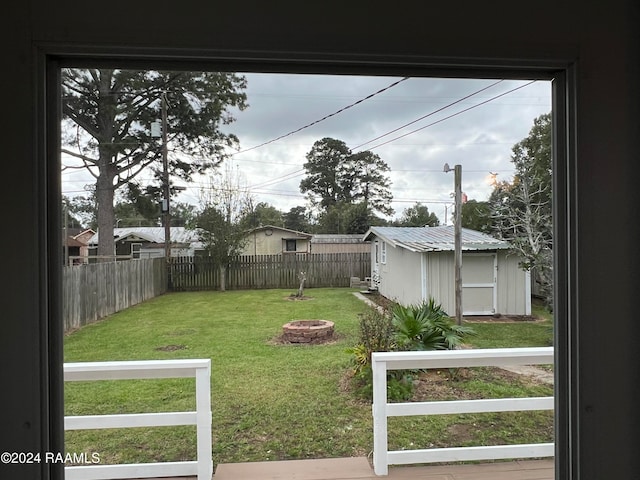 view of yard with an outdoor fire pit and a storage shed