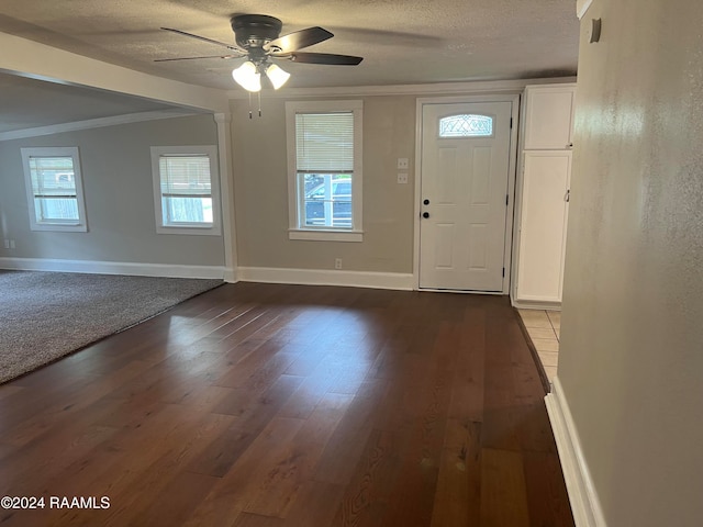 foyer entrance with ornamental molding, wood-type flooring, and a healthy amount of sunlight