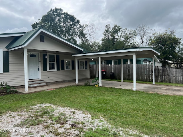 view of front of home featuring a front lawn, covered porch, and a carport