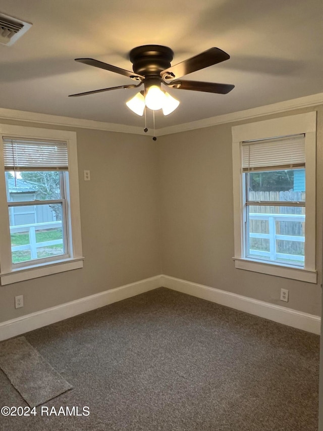 empty room with ornamental molding, ceiling fan, carpet flooring, and a healthy amount of sunlight