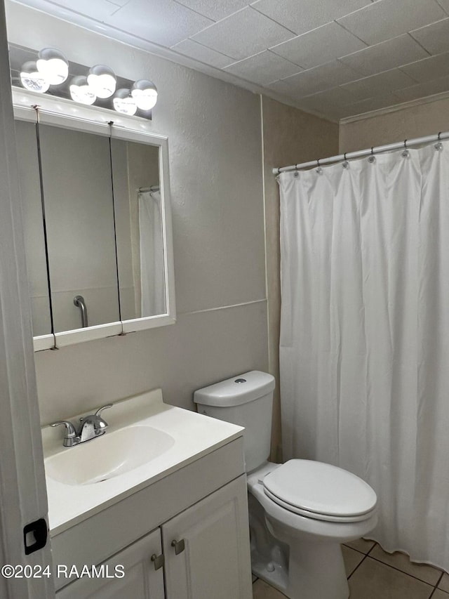 bathroom with toilet, vanity, tile patterned floors, and curtained shower