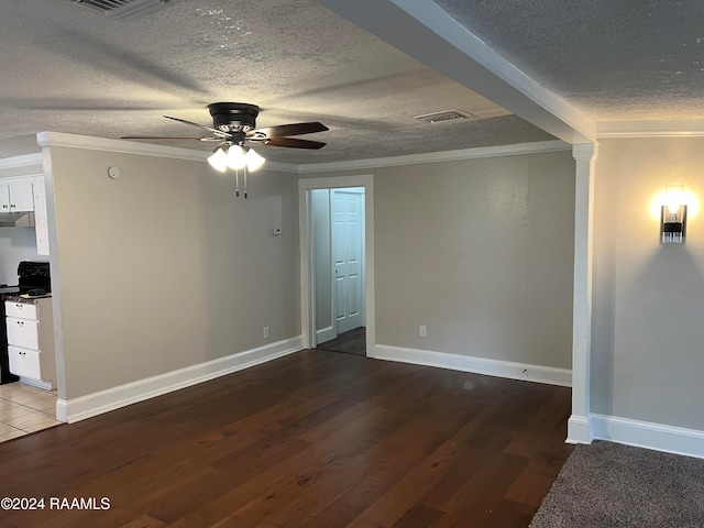 empty room featuring ceiling fan, a textured ceiling, dark hardwood / wood-style flooring, and crown molding