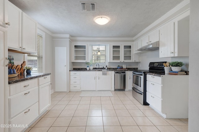 kitchen featuring visible vents, glass insert cabinets, under cabinet range hood, appliances with stainless steel finishes, and white cabinets