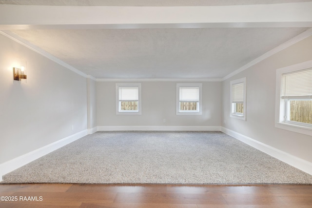 empty room featuring baseboards, wood finished floors, and ornamental molding