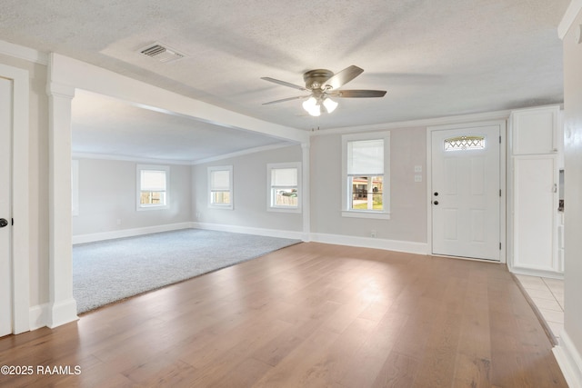 entrance foyer with a ceiling fan, baseboards, visible vents, light wood finished floors, and a textured ceiling