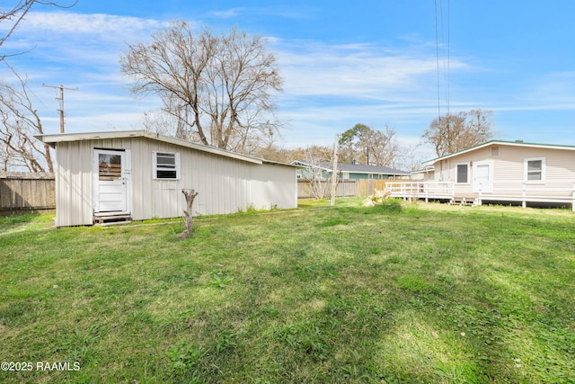 view of yard featuring an outdoor structure and fence