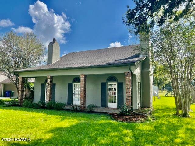 back of house featuring a lawn