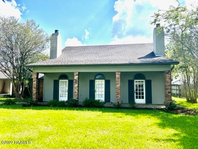 rear view of property featuring a lawn