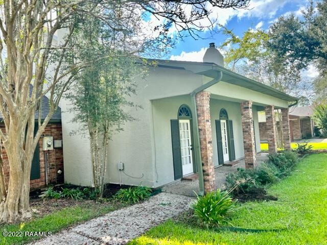 view of side of home with a yard