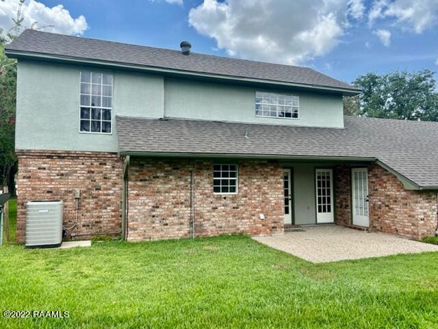 back of house featuring a lawn, cooling unit, and a patio