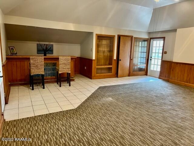 interior space featuring light tile patterned floors and vaulted ceiling