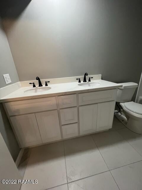 bathroom with vanity, tile patterned floors, and toilet