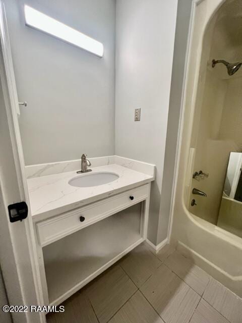 bathroom featuring washtub / shower combination, vanity, and tile patterned floors