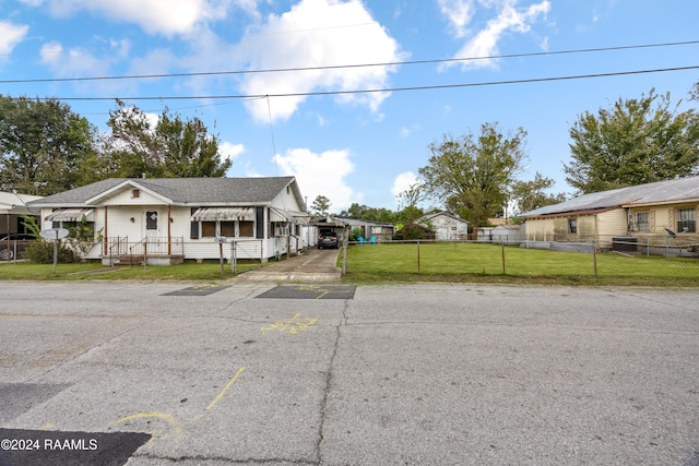 view of front of home with a front yard and a carport