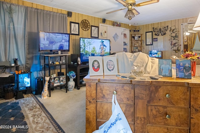 interior space featuring ceiling fan and wood walls