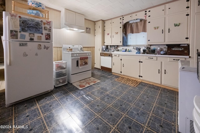 kitchen featuring white cabinetry, white appliances, and wooden walls