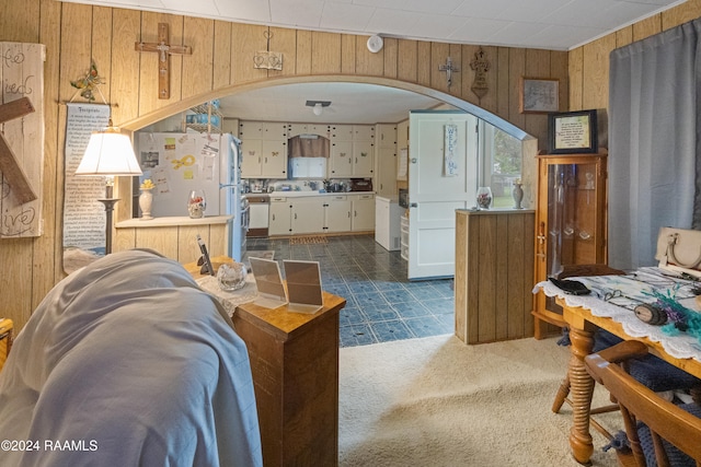 carpeted living room with wood walls