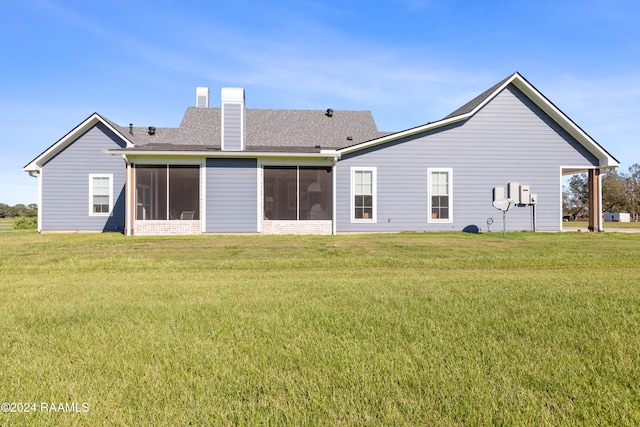 back of property with a sunroom and a yard