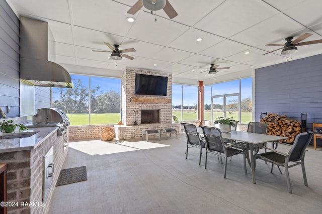 view of patio with an outdoor brick fireplace, sink, and an outdoor kitchen